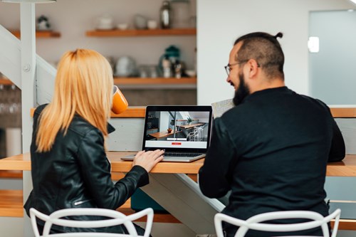 Couple researching on laptop