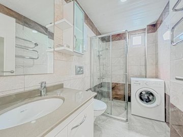 A Pristine Apartment For Sale In Avsallar - A luxurious family bathroom with washing machine
