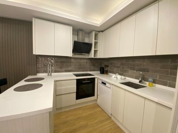Refurbished Antalya Apartment Near Lara Beach For Sale - Modern kitchen with appliances installed and a breakfast bar