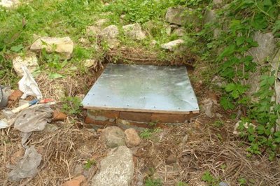 Brick-lined water valve pit with water valve in garden area