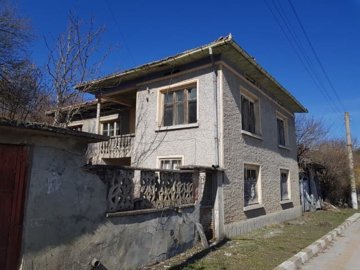 Close-up of house corner featuring a balcony with decorative concrete balustrade and multiple windows