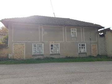 Exterior view of the two-storey house showing the front facade with three windows and a tiled roof
