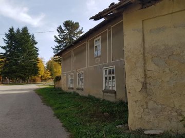 Front view of the house showing three windows and a tiled roof adjacent to a paved road
