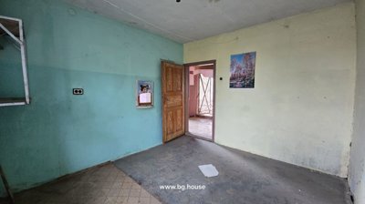 Room featuring turquoise and pale yellow painted walls with an open wooden door leading to another room.