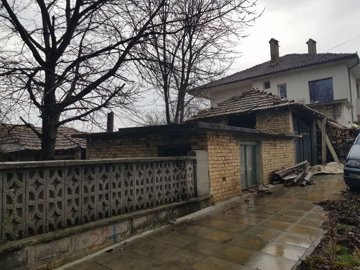 View of the brick outbuilding adjacent to the two-storey house with bare trees