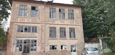 Detailed view of the building's exterior showing aged plaster and window frames