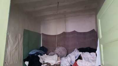 Interior space with white walls and a pile of clothes or fabric on the floor
