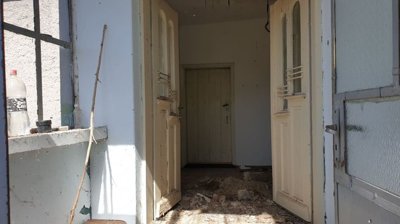Corridor inside the house showing white walls and several open doors leading to adjacent rooms