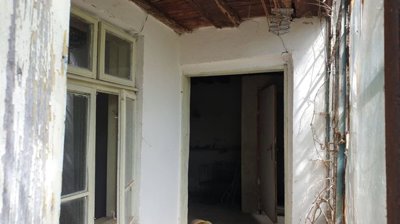 Interior corridor showing white walls, wooden ceiling beams, and open doors to adjacent rooms