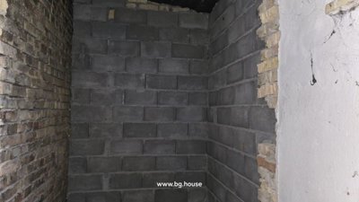 Interior corner showing exposed brick and concrete block walls in unfinished condition