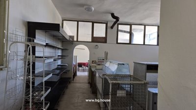 Interior space containing metal shelving units and display counters, likely for commercial use