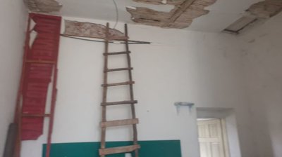 Interior space showing a wooden ladder against the wall and ceiling with exposed wooden beams