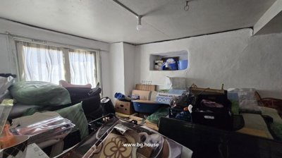 Room interior showing window, white walls, and assorted stored items and boxes