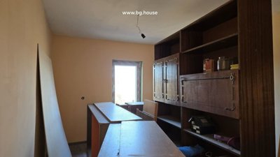 Interior room featuring wooden shelving units and scattered household items