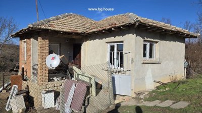 Close-up image showing the corner of a Bulgarian house with stone base and plastered walls