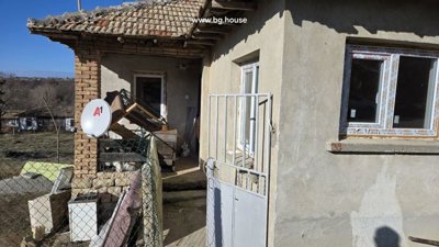Entrance to the Bulgarian house featuring an open metal gate and a small porch area