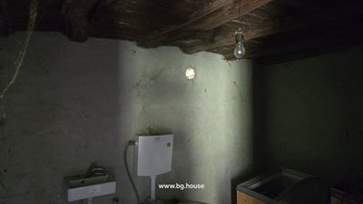 Bathroom interior showing toilet, basin, and storage crate with glass jars