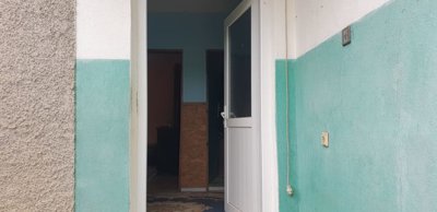Front entrance door of the house showing turquoise and white painted exterior walls