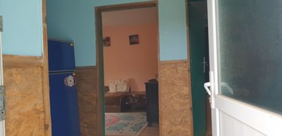 Interior view from entrance showing rooms with blue and peach colored walls and furniture