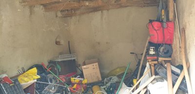 Interior view of a storage room containing tools, boxes, and miscellaneous equipment