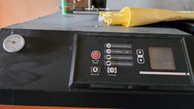 Control panel of the heating system showing temperature and fan settings with a pressure gauge