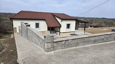 View of the house enclosed by a concrete block wall with yard space around