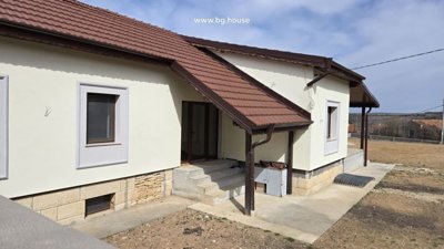 Side entrance showing concrete steps, windows, and brown tiled roof