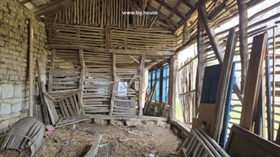 Corner inside the wooden shed with slatted walls and assorted construction materials and tools