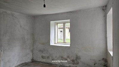 Small room featuring white plastered walls and two windows providing natural light