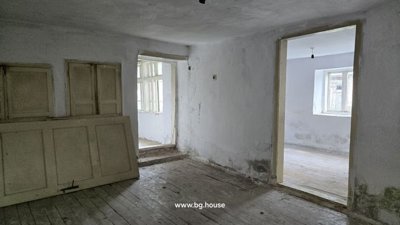 Room with white walls, wooden floor, and a door with glass panels opening to the outside