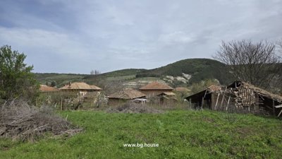 Cluster of village houses and barns surrounded by green fields and hills
