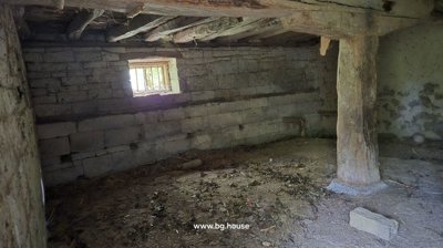 Stone cellar interior featuring a small window and wooden beams supporting the ceiling.