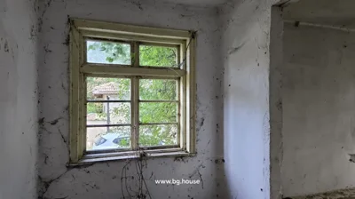 Empty room with white walls, an open door, and plastic bottles scattered on the floor