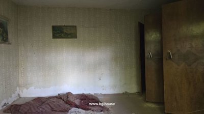 Interior room featuring patterned wallpaper, two wooden wardrobes, and a mattress laid on the floor.