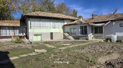 Back of the Bulgarian house featuring an enclosed porch with large windows and stone steps leading to the yard
