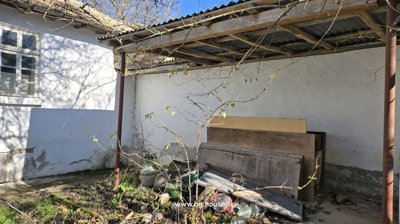 Covered outdoor space with white walls and stored wood