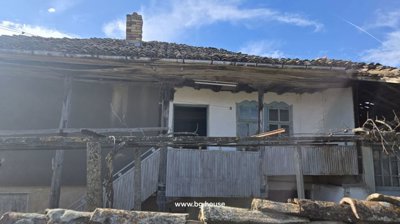 Close-up showing wooden balcony structure and windows on Bulgarian house exterior