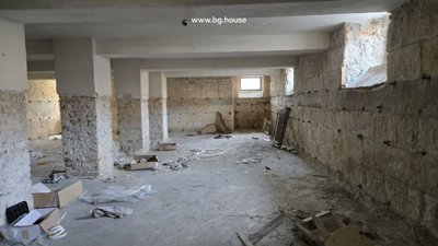 Unfinished basement area with exposed stone walls and concrete floor