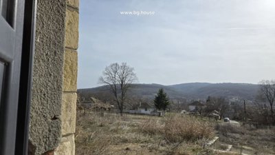 Scenic view of village houses and hills seen through a school window