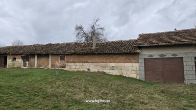 Outbuilding constructed with stone and brick walls, tiled roof, and grassy yard area.
