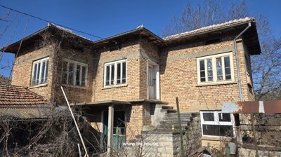Two-storey brick house with external stone staircase and tiled roof
