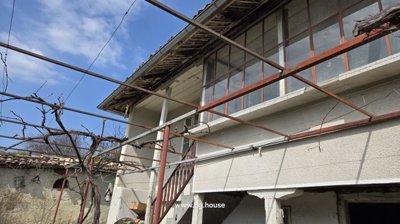 Close-up of external stairs leading to upper floor of Bulgarian house with garden vines on metal trellis