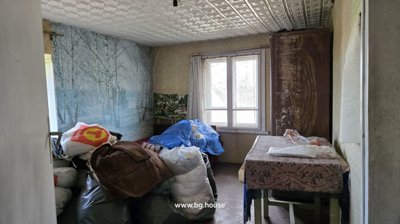 Bedroom containing a bed, table, and a large mural of a forest path covered in autumn leaves on the wall.