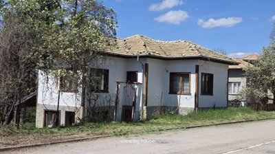 White house with tiled roof and wooden windows in village Dolets