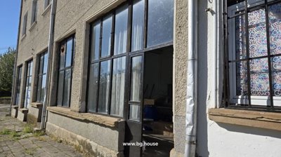 Outdoor view showing the building's facade with multiple large windows and an open entrance door.