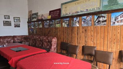 Interior space with wooden panel walls decorated with framed pictures and a sofa seating area