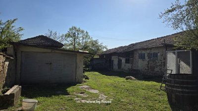 Garden area showing a garage, old buildings, and a grassy path