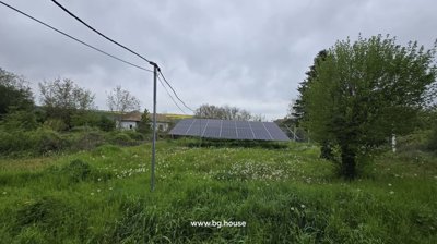 Wide-angle view of solar panels installed in the garden with surrounding greenery and nearby houses.