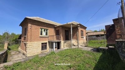 Wide exterior view showing brick walls, stone base, and tiled roof of the house