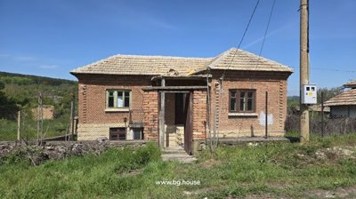 View of the back of the house showing stone base, brick walls, windows, and fenced garden